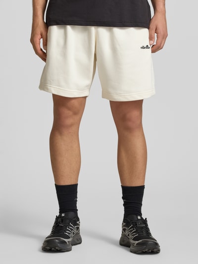 Männermodel trägt Shorts mit Logo-Stitching Modell 'ZANICA' von Ellesse, crèmefarben, lockere Passform, Nahaufnahme Oberschenkel, Vorderansicht.