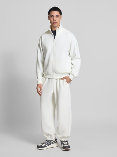 Männermodel trägt Regular Fit Sweatpants mit Modal-Baumwoll-Anteil von adidas Sportswear, unifarben weiß, Sweat-Material, Ganzkörperansicht von vorne.