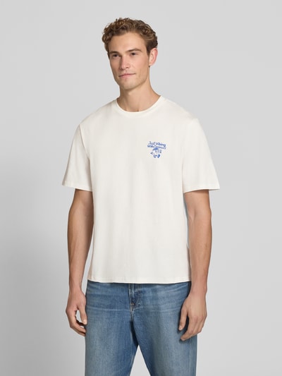 Männermodel trägt weißes Regular Fit T-Shirt aus reiner Baumwolle Modell 'VIBING COCO' von REVIEW, Printdetails, Nahaufnahme Oberkörper, Herren T-Shirt von REVIEW x ANSON´S, Rückenlänge M: 68 cm.