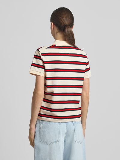 Frauenmodel trägt Regular Fit Poloshirt aus Baumwoll-Mix von Tommy Hilfiger, gestreift, kurzarm, Logo-Detail, Ganzkörperansicht Rückansicht.