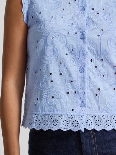 Frauenmodel trägt Relaxed Fit Blusentop aus reiner Bio-Baumwolle Modell 'EMILY' von Vero Moda, hellblau, Lochstickerei, Nahaufnahme Oberkörper.