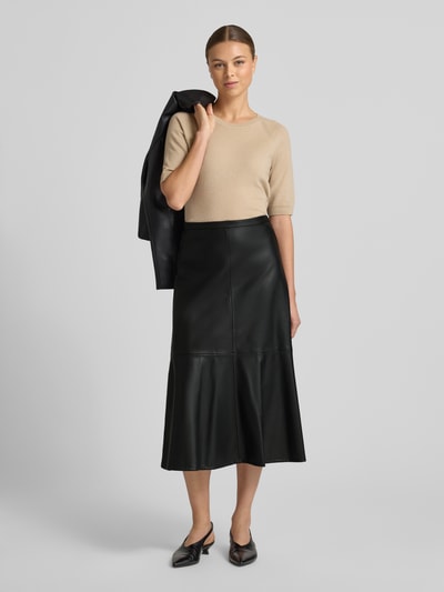 Frauenmodel trägt Midirock in Leder-Optik Modell 'PARIS' von Mango, lockerer Schnitt, schwarz, Nahtreißverschluss, Ganzkörperansicht von vorne.