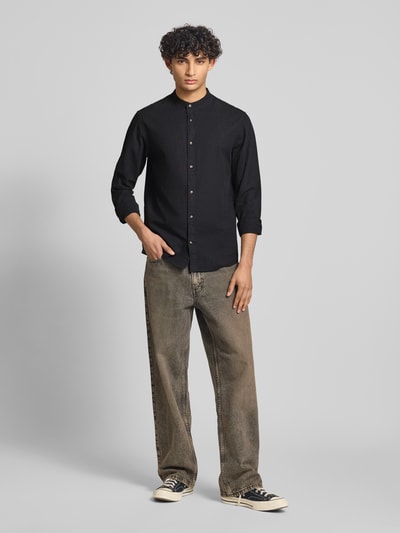 Männermodel trägt Regular Fit Freizeithemd aus Baumwoll-Leinen-Mix von Jack & Jones in Schwarz mit Stehkragen, Ganzkörperansicht von vorne.