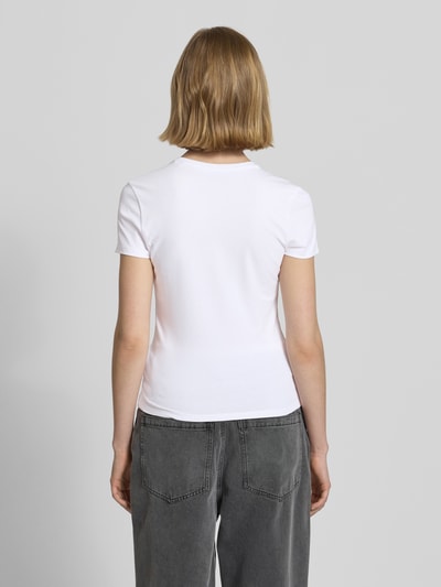 Frauenmodel trägt Slim Fit T-Shirt mit Motiv-Stitching von REVIEW, weißer elastischer Baumwoll-Mix, Rückansicht Ganzkörperansicht.