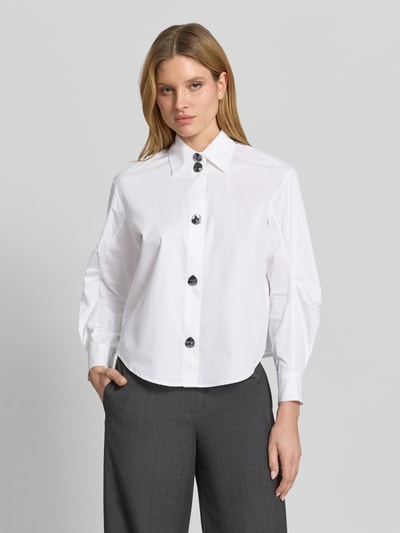 Kobiece model prezentuje Regular Fit Bluse aus Baumwolle mit Ballonärmeln von ARMANI EXCHANGE, biała, kołnierzyk koszulowy, listwa guzikowa, bufiaste rękawy, czysta bawełna, długość tyłu 57 cm w rozmiarze S, długość rękawów 57 cm w rozmiarze S, krój regular fit, widok na cały przód.