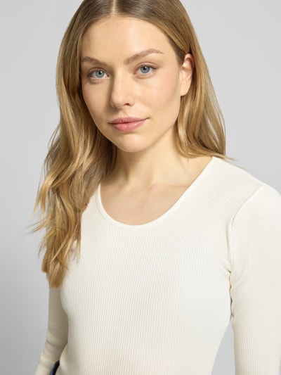 Frauenmodel trägt Longsleeve mit Seiden-Anteil Modell 'Elaine' von MOS MOSH in Offwhite, Baumwoll-Seiden-Mix, fein gerippte Textur, Rundhalsausschnitt, Körpernahe Passform, Muschelsaum, Nahaufnahme Oberkörper.