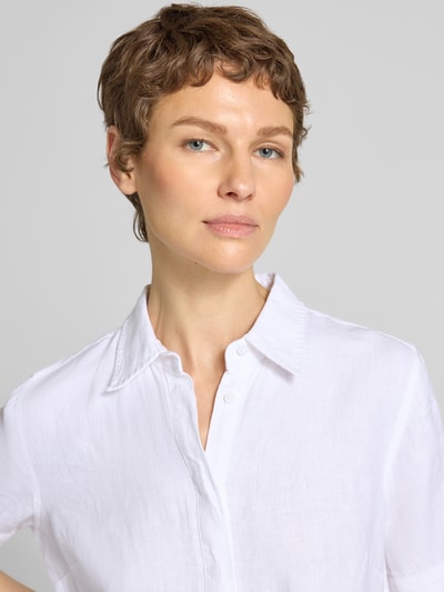 Frauenmodel trägt körpernahes Blusenkleid aus reinem Leinen von Polo Ralph Lauren in Weiß mit Spitzkragen, Nahaufnahme Oberkörper.
