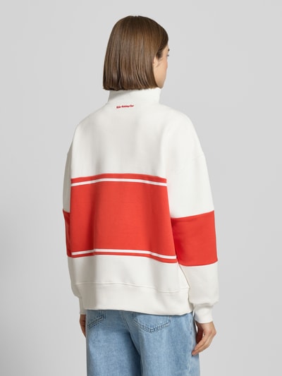 Frauenmodel trägt Relaxed Fit Sweatshirt mit Stehkragen Modell 'Jenny' von LeGer by Lena Gercke, Baumwoll-Mix, rote und weiße Farbe, Stitchings, Reißverschluss, Ganzkörperansicht Rückansicht.