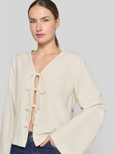 Frauenmodel trägt Blusenshirt aus Viskose-Mix mit Schnürung von Vila, Regular-Fit, Modell PRISILLA, V-Ausschnitt, helle Farbe, textil strukturierte Oberfläche, Ganzkörperansicht von vorne. Rückenlänge 56 cm, Ärmellänge 61 cm bei Größe 36.