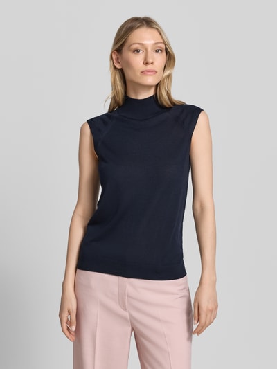 Frauenmodel trägt Slim Fit Pullunder aus reiner Schurwolle Modell 'FIPINI' von BOSS in Dunkelblau zu rosa Hose, Damen, Ganzkörperansicht von vorne.