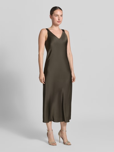 Frauenmodel trägt Regular Fit Midikleid mit V-Ausschnitt Modell 'Qova' von someday, aus olivgrünem Satin, ärmellos, Ganzkörperansicht von vorne.