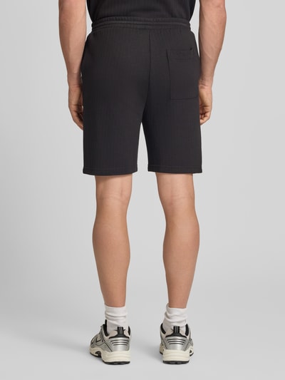 Männermodel trägt Regular Fit Bermudas aus strukturiertem Material Modell 'TREY LIFE' von Only & Sons, Optik: Unifarben, Ganzkörperansicht Rückansicht.
