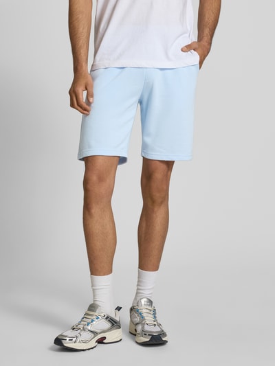 Mężczyzna nosi Sweatshorts mit elastischem Bund Modell 'KARLOS' von Blend, bawełniany miks, kolor jasnoniebieski, krój regular fit, szerokość w rozmiarze M 42 cm, długość nogawki 21 cm, widok całej sylwetki z przodu.
