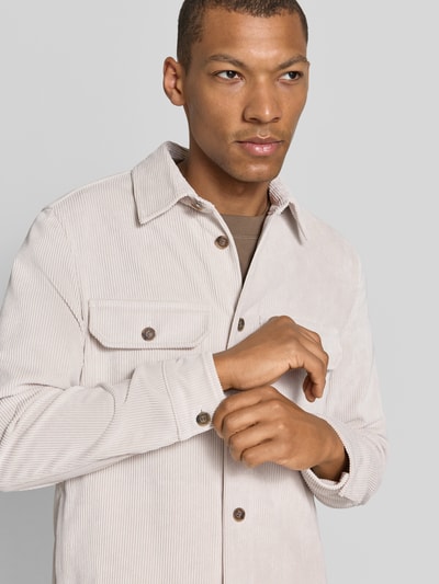 Männermodel trägt Regular Fit Hemdjacke aus Cord Modell 'CIPOLPO' von CINQUE in Beige, Knopfleiste, Brusttaschen, Nahaufnahme Oberkörper.
