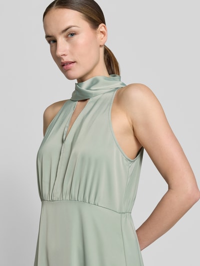 Frauenmodel trägt Maxikleid aus Satin mit Stehkragen Modell 'Thea' von YAS in Hellgrün, Elastischer-Material-Mix, taillierte Passform, Ärmelloses-Design, Schlüsselloch-Ausschnitt, Nahaufnahme Oberkörper.