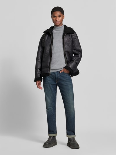 Männermodel trägt Regular Fit Jacke in Leder-Optik von Lindbergh mit Kunstfellbesatz und Umlegekragen, dunkel, Ganzkörperansicht von vorne.
