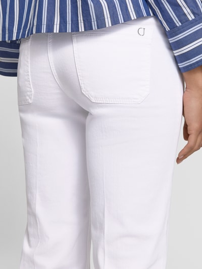 Frauenmodel trägt Relaxed-Fit Jeans aus Baumwoll-Mix Modell 'TESS' von Cambio in weißer Denim-Optik mit Logo-Applikation, Label-Patch, Gesäßtaschen, Fransen-Beinabschluss und Twill-Materialverarbeitung, Nahaufnahme Rückansicht.