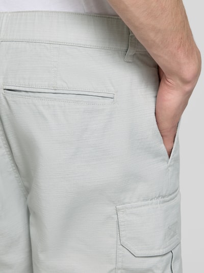 Männermodel trägt Relaxed Fit Bermudas aus reiner Baumwolle Modell 'DRAFTMEN' von Barbour in Optik: Unifarben mit Cargotaschen, Detailaufnahme.