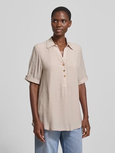 Vrouwenmodel draagt Relaxed Fit Bluse aus Viskose-Mix mit Umlegekragen van Apricot in lichtbeige met knoopsluiting, halflange mouwen, verlengde rugzijde, ruglengte maat S 82 cm, mouwlengte 28 cm, ganzekörperaanzicht van voren.