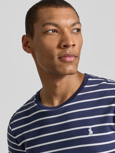 Männermodel trägt Regular Fit T-Shirt aus reiner Baumwolle von Polo Ralph Lauren mit Optik:Allover-Muster, Logo-Stitching, Rundhals, Kurzarm, Sweat, Nahaufnahme Oberkörper.
