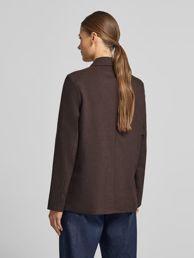 Vrouwenmodel draagt Loose Fit Longline Blazer met schoudervullingen van VERO MODA in effen donkerbruin, geweven stof, lange mouwen, reverskraag, sierknopen, klepzakken, 2-knoopsluiting, taille- en deelnaden, productfoto vanuit achteraanzicht.