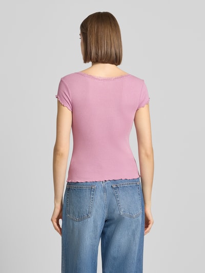 Frauenmodel trägt Slim Fit T-Shirt aus Viskose-Mix mit Spitzenbesatz von Review in Rosa, schlichte Textur, Rückenlänge 51 cm, Ganzkörperansicht Rückansicht.