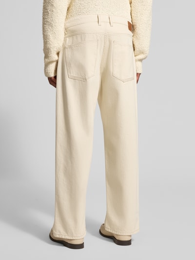 Männermodel trägt Relaxed Fit Jeans aus reiner Baumwolle von Drykorn in Creme mit 5-Pocket-Design, Label-Patch, Ganzkörperansicht Rückansicht.