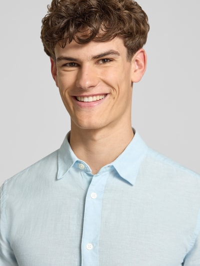 Männermodel trägt Slim Fit Freizeithemd aus Baumwoll-Leinen-Mix Modell 'CAIDENLS SOLID' von Only & Sons, Optik: Unifarben, Nahaufnahme Oberkörper.