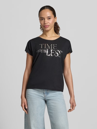 Frauenmodel trägt T-Shirt mit Statement-Print und Rundhalsausschnitt von Christian Berg Woman aus Baumwoll-Viskose-Mix, Regular-Fit, schwarze Farbe, Rückenlänge bei Größe S 66 cm, Ganzkörperansicht von vorne.