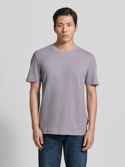 Männermodel trägt Regular Fit T-Shirt aus Baumwoll-Mix von Tom Tailor Denim in Optik: Unifarben, Materialverarbeitung: Piqué, Ganzkörperansicht von vorne.