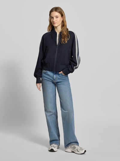 Frauenmodel trägt Regular Fit Sweatjacke mit Viskose-Anteil von Marc O'Polo Denim in Dunkelblau, Kontraststreifen, Reißverschluss, ganzkörperansicht von vorne.