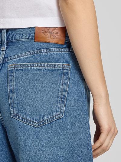 Frauenmodel trägt High Waist Jeansshorts mit Label-Detail von Calvin Klein Jeans in Blau, reine Baumwolle, Nahaufnahme Rückansicht.