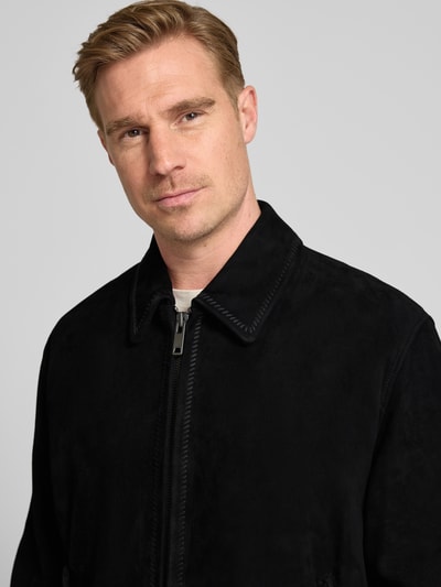 Mannelijk model draagt Super Slim Fit Lederjacke aus Ziegenleder model 'Lemai' van HUGO in suèdelook, labelopschrift, zwart, ritssluiting, platte kraag, materiaal: echt geitenleer, nahaufnahme bovenlichaam.