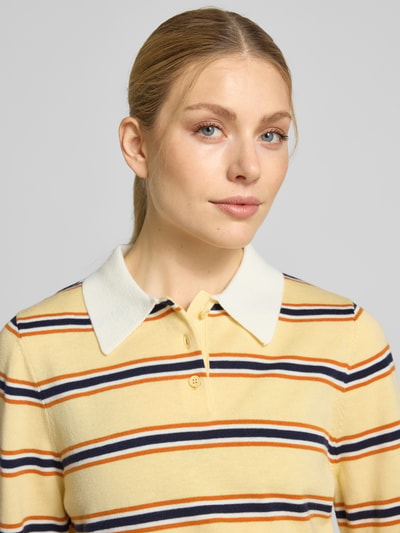 Frauenmodel trägt Regular Fit Poloshirt mit Knopfleiste Modell 'PREGO' von SUNCOO PARIS, gestreift, Materialmix mit Lanawoll-Anteil, Nahaufnahme Oberkörper.