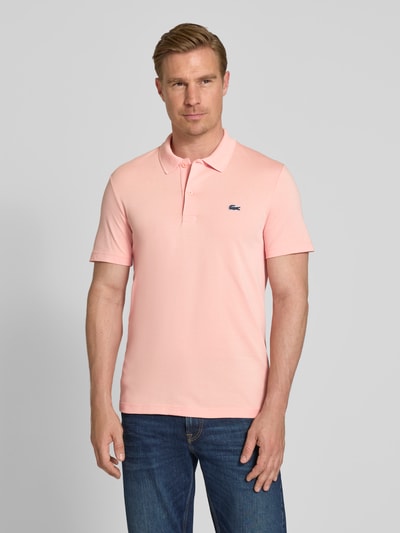 Männermodel trägt Regular Fit Poloshirt aus Baumwoll-Mix von Lacoste, Optik: Unifarben, Logo-Patch, Polokragen, Kurzarm, Ganzkörperansicht von vorne.