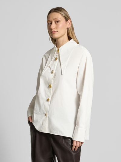 Frauenmodel trägt Oversized Hemdbluse aus reiner Baumwolle Modell 'JOMATO' von Essentiel Antwerp in Weiß, klare Linien, glatte Textur, Nahaufnahme Oberkörper.