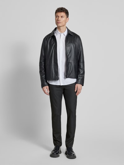 Männermodel trägt Hose mit Eingrifftaschen Modell 'Chuck' von Brax, Regular Fit, dunkler Farbton, Material-Mix, Ganzkörperansicht von vorne.