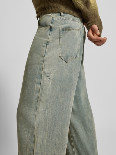 Männermodel trägt Wide Fit Jeans im Used-Look von ANOTHER COTTON LAB, Baumwoll-Mix mit Viskose-Anteil, Eingrifftaschen, Nahaufnahme Oberkörper.