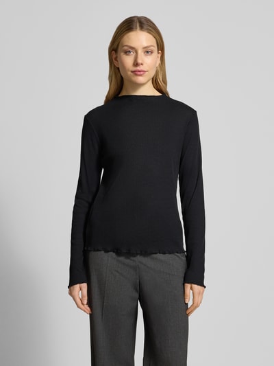 Modelka nosi Slim Fit Langarmshirt mit Viskose-Anteil von s.Oliver RED LABEL, czarny, rippstrick, frill na mankietach i dole, jednokolorowy, krój slim fit, label stitching, wysoki dekolt, długi rękaw, widok całej sylwetki z przodu.