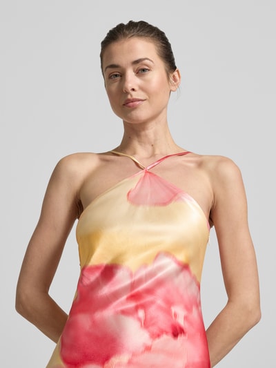 Frauenmodel trägt Maxikleid aus Viskose mit Allover-Look von Forever New in Gelb und Pink, A-Linie, Neckholder, Nahaufnahme Oberkörper.
