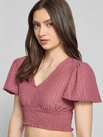Frauenmodel trägt Regular Fit Crop Top mit Strukturmuster Modell 'HANNAH' von Only, Optik: Unifarben, gesmoktes Brustband, V-Ausschnitt, Schmetterlingsärmel, Kurzarm, Rumpfabschluss: Smok, Nahaufnahme Oberkörper.