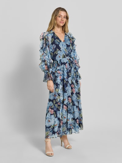 Vrouwenmodel draagt Maxikleid met Rüschen und Knopfleiste van Oui, blauw met bloemenprint, getailleerd model, V-hals, mouwen met ruches, knoopsluiting, volantzoom, ruglengte maat 36: 135 cm, borstwijdte maat 36: 39 cm, mouwlengte maat 36: 59 cm, volledig lichaam vooraanzicht.