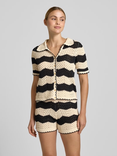 Kobiece modelka nosi Regular Fit Cardigan aus reiner Baumwolle Modell 'GOLDEN COVE' od Vero Moda, bawełniana dzianina, paski, krótki rękaw, krój regular fit, beżowo-czarne barwy, widok całej sylwetki z przodu.