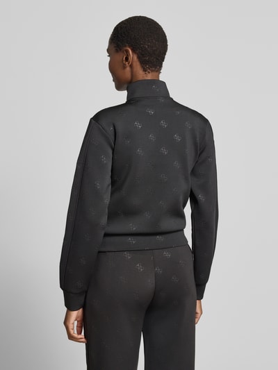 Frauenmodel trägt schwarze Sweatjacke mit Logo-Muster Modell 'CALISTA' von Guess Activewear, Material-Mix mit Stretch-Anteil, Ganzkörperansicht Rückansicht