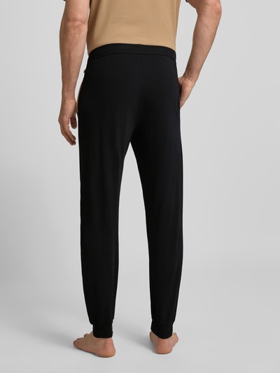 Männermodel trägt Comfort Fit Sweathose aus Baumwoll-Mix Modell 'MIX&MATCH PANTS' von BOSS, Optik: Unifarben, Ganzkörperansicht Rückansicht.