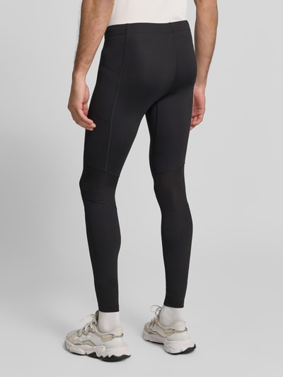 Männermodel trägt Tights mit elastischem Bund und Logo von ASICS, schwarz, körpernahe Passform, Materialmix mit Stretch, Ganzkörperansicht Rückansicht