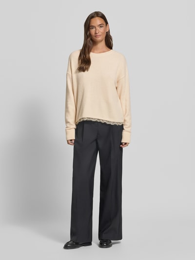 Vrouwenmodel draagt Strickpullover mit Spitze und Rundhalsausschnitt van Milano Italy in beige, relaxed fit, materiaal-mix met alpacawol, kanten rand, gecombineerd met zwarte broek, geheellichaamsaanzicht van voren