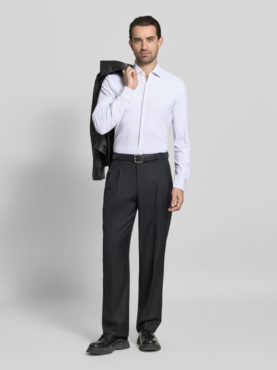 Męski model nosi Slim Fit Businesshemd mit Kentkragen Modell 'KENNO' von HUGO, efekt: wzór na całej powierzchni, krój slim fit, kołnierzyk typu kent, jednorzędowa listwa guzikowa, wyhaftowane logo, długi rękaw, mankiet, zaokrąglone wykończenie, pas na plecach, kolor biały z drobnym wzorem, gładka tekstura, Ganzkörperansicht von vorne.