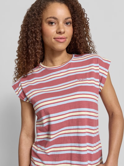 Frauenmodel trägt Regular Fit T-Shirt aus reiner Baumwolle Modell 'CHARLOT' von Pepe Jeans, Optik: gestreift, Label-Stitching, Rundhals-Ausschnitt, Kurzarm, Materialverarbeitung: Jersey, Farbe rot-weiß, Nahaufnahme Oberkörper.