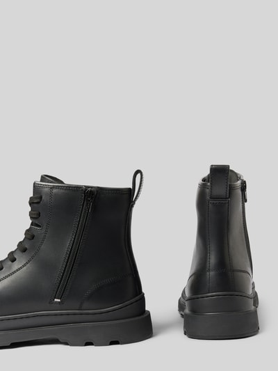 Produktfoto, Stiefel aus echtem Leder Modell 'Brutus' von Camper, schwarze Farbe, profilierte Sohle, abgerundete Passform, Schnürverschluss, sichtbarer Reißverschluss, Schafthöhe und Schaftweite für Größe 44, strukturierte Lederoberfläche